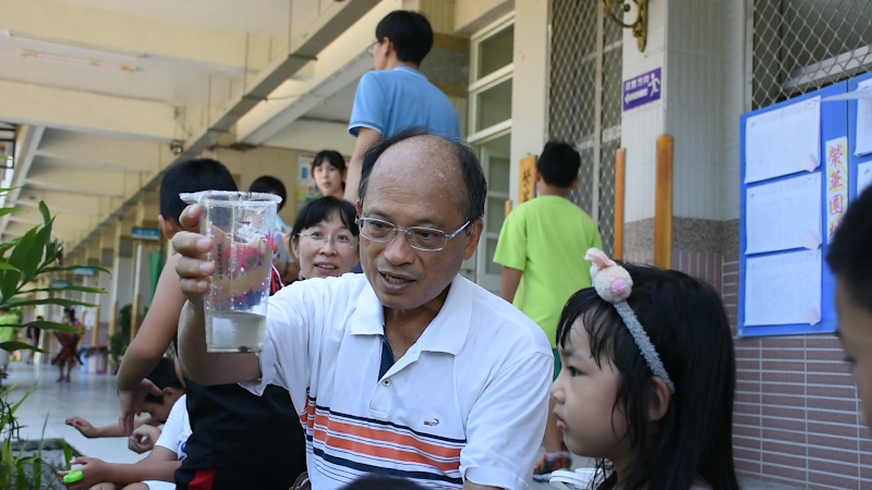 圖01：榮華國小校長邱坤玉帶著學童觀察小蝌蚪，教導孩童生命循環概念。攝影／陳葳倫